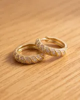 Caravanas de acero dorado en forma de argolla mediana, con pavé de circonias brillantes en la mitad frontal.