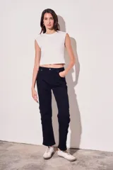 Pantalón de jean negro, de corte recto y tiro medio. Presenta bolsillos delanteros y traseros, y una hilera de botones metálicos a lo largo de la costura lateral.