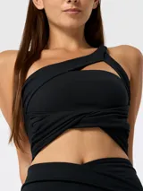 Top deportivo negro de un solo hombro con diseño frontal de cortes asimétricos y drapeado.