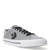 Championes Converse modelo Casual OX Classic, de corte bajo, confeccionados en lona gris con detalles en negro. Presentan el logo de estrella y chevron en el lateral, cordones negros y suela de goma blanca con una línea decorativa negra.
