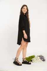 Camisa negra oversize de manga larga con cuello camisero y cierre frontal con botones.