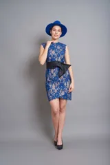 Vestido corto de encaje azul con forro color nude, sin mangas y lazo negro a la cintura.