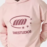 Hoodie de corte oversize color rosado con capucha, manga larga y estampa frontal del logo de la marca en tono marrón.