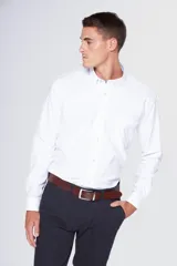 Camisa blanca de tela oxford con manga larga y logo bordado en el bolsillo. Cuello con botones y tablón central en la espalda.