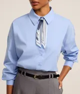 Camisa celeste oversized de tricolina con cuello, abotonado delantero y mangas largas. Incluye pañuelo estampado para el cuello.