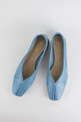 Mocasines de cuero metalizado color gris, con diseño de punta cuadrada y costura central fruncida en la capellada.