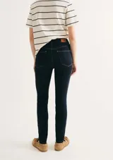 Pantalón de jean corte skinny, de tiro medio y color azul oscuro con costuras en contraste.