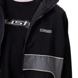 Campera rompevientos Rusty modelo Pipper, color negro con paneles laterales y frontales en gris. Cuenta con cierre frontal, puños elásticos y logo de la marca en el pecho.