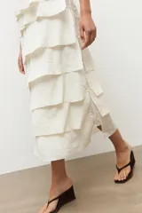 Maxi vestido crudo sin mangas con múltiples volados horizontales escalonados y escote redondo.