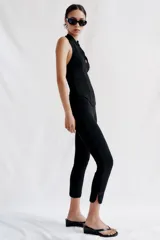 Pantalón capri negro de tiro medio con cintura elástica y detalle de alamares en el bajo.