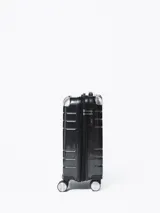 Valija rígida negra con diseño geométrico, manija extensible y cuatro ruedas con giro de 360 grados.