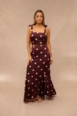 Falda midi color ciruela con estampado de lunares rosados, corte sirena y terminación con volados en el ruedo.
