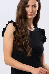 Remera de algodón color negro con cuello redondo y mangas cortas adornadas con volados.