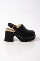 Zuecos negros de cuero con plataforma, tacón de bloque y tachuelas doradas.