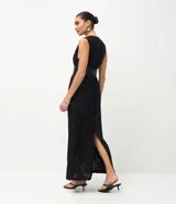 Vestido midi sin mangas, confeccionado en tejido jersey con textura floral flocada. Presenta cuello redondo y detalle de encaje en la espalda.