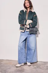 Cartera bandolera negra con tachas plateadas, confeccionada en gamuza vegana.