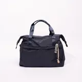 Bolso tipo tote azul marino con doble asa corta y dije colgante con la palabra "Traveller".