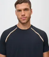 Remera deportiva Get Over de poliéster y elastano, color negro, con tecnología dry, cuello redondo y mangas cortas de corte raglán con detalles de líneas en contraste.