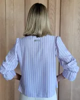 Blusa de algodón con cuello mao y volados, mangas largas con puños elásticos y corte holgado.