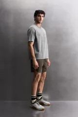 Camiseta de corte regular fit confeccionada en algodón, con cuello redondo y manga corta. Presenta un estampado frontal con el texto 'ATHLETICZ TRAINING CREW' con efecto desgastado.