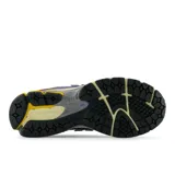 Championes New Balance modelo 1906R, de color beige con detalles en azul, negro, gris y amarillo.