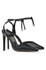 Zapato de tacón alto color blanco, con punta fina y tira fina con nudo en el tobillo.