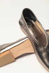 Chatas planas de cuero vacuno, color peltre metalizado, con punta cuadrada y escote pronunciado en el empeine.