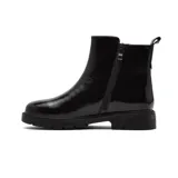 Bota corta de cuero charolado color negro, con suela track de goma y detalle de aplique metálico con diseño floral en el lateral.