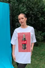 Remerón de algodón blanco con corte oversize y cuello redondo, que presenta un estampado frontal con diseño de una lata de sardinas sobre fondo de rayas.