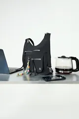 Mochila tipo hobo color negro, con diseño versátil que permite usarla como cartera. Cuenta con múltiples bolsillos frontales con cierres metálicos, correa regulable y un llavero decorativo con cuentas de colores removible.