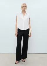 Camisa sin mangas de lyocell, color blanco, con cuello camisero y cierre frontal de botones.