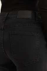 Pantalón de jean azul oscuro, de corte cropped y acampanado, con ruedo desflecado.