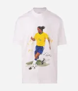 Remera de algodón con corte relaxed, cuello redondo y mangas cortas. Presenta un estampado frontal con una ilustración estilo acuarela de Ronaldinho jugando al fútbol.