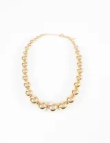 Collar corto dorado con cadena de eslabones y cuentas esféricas de diferentes tamaños.