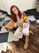 Sweater de punto con diseño geométrico en tonos mostaza, marrón y beige.