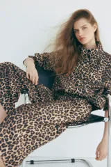 Pantalón palazzo de corte holgado con estampado de leopardo, piernas amplias, pinzas y bolsillos laterales.