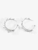 Aros tipo argolla plateados con apliques de mariposas y flores.