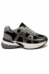 Zapatillas urbanas de estilo chunky, color negro con detalles en gris y plateado, confeccionadas en malla y material sintético, con suela robusta y cordones grises.