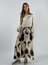 Pollera larga de tiro alto con estampado abstracto en tonos beige, marrón y negro.