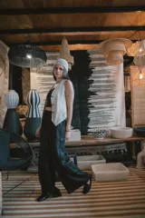 Pantalón de corte amplio y tiro alto, confeccionado en tela negra con acabado brillante y sutil efecto glitter. Presenta cintura elástica con cordón ajustable y caída fluida.