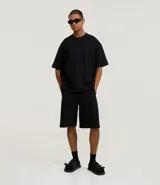 Bermuda masculina de algodón y poliéster, color gris oscuro, con cintura elástica y cordón ajustable. Presenta bolsillos funcionales.