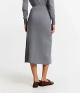 Pollera midi gris de punto, con detalle delantero cruzado.