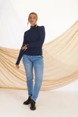 Sweater rojo de punto con cuello alto y mangas largas. Presenta detalles de costuras verticales en color azul en la parte delantera y en los hombros.