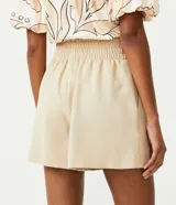 Short color beige de sastrería con cintura alta, cinturilla ancha, elástico y botones.