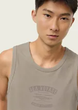 Musculosa de hombre color beige, de corte clásico y sin mangas, con pequeño estampado tipográfico en el pecho.
