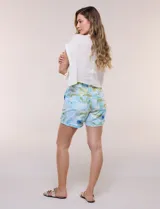 Short de lino con silueta relajada, estampado en tonos azules y tierra sobre fondo blanco. Posee cintura elastizada con cordón ajustable, bolsillos laterales y dobladillo en las piernas.