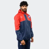 Campera de lluvia Umbro del Club Nacional de Football, con diseño de bloques de color blanco y azul marino. Presenta capucha, cierre frontal completo, puños elásticos y detalles de piping en color rojo. Incluye logo de la marca y escudo del club en el pecho.