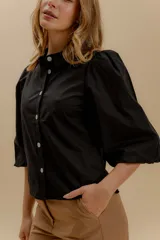 Camisa a rayas verticales rojas y blancas, con cuello bebé, mangas globo 3/4 y botones nacarados.