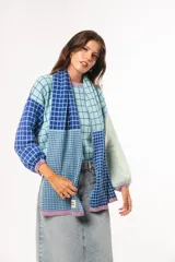 Bufanda tejida a crochet con diseño a cuadros en celeste y azul.