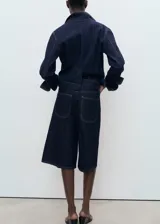 Short de jean de tiro medio con diseño recto, confeccionado en algodón estilo tejano vaquero. Cuenta con cuatro bolsillos y cierre oculto de botón, gancho y cremallera.